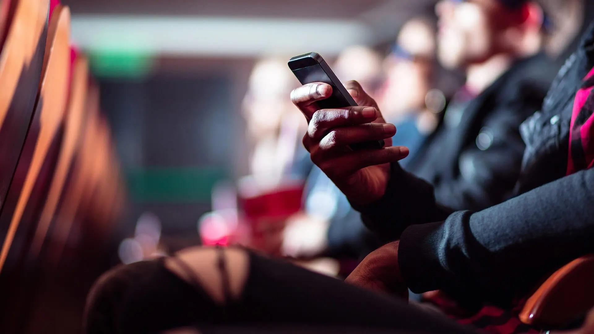 An audience member uses a smartphone.