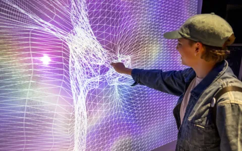 Student interacts with a multi-colored touchable screen.