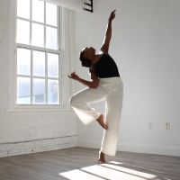 Kaisha Snowden strikes a dance pose in front of a large window in an empty room.