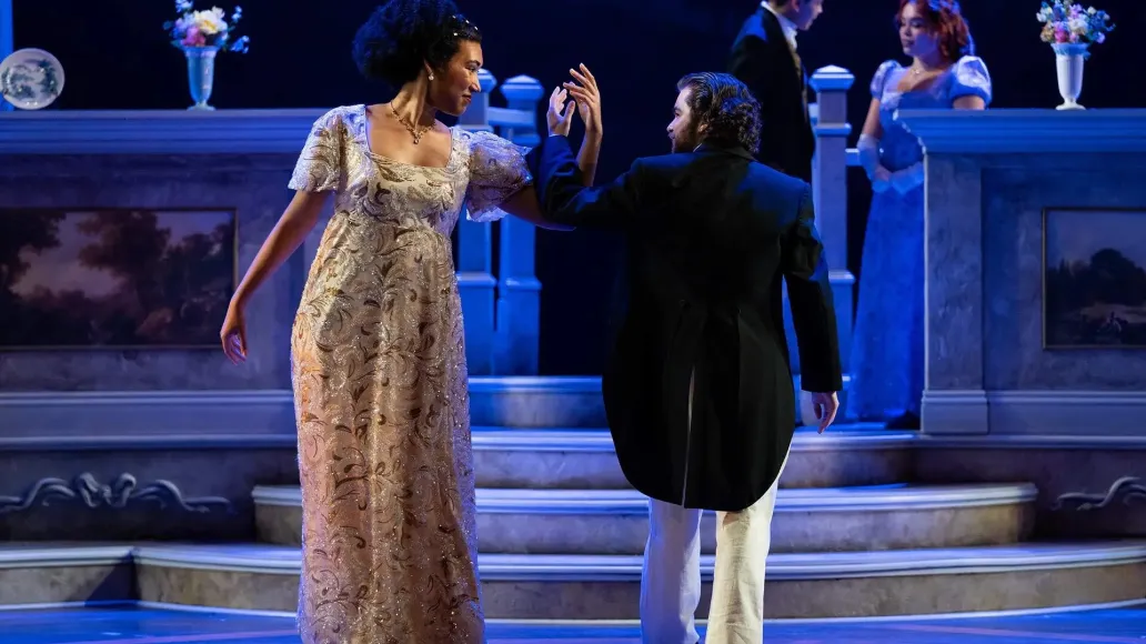 Actors playing Emma Woodhouse and George Knightley dance together on stage.