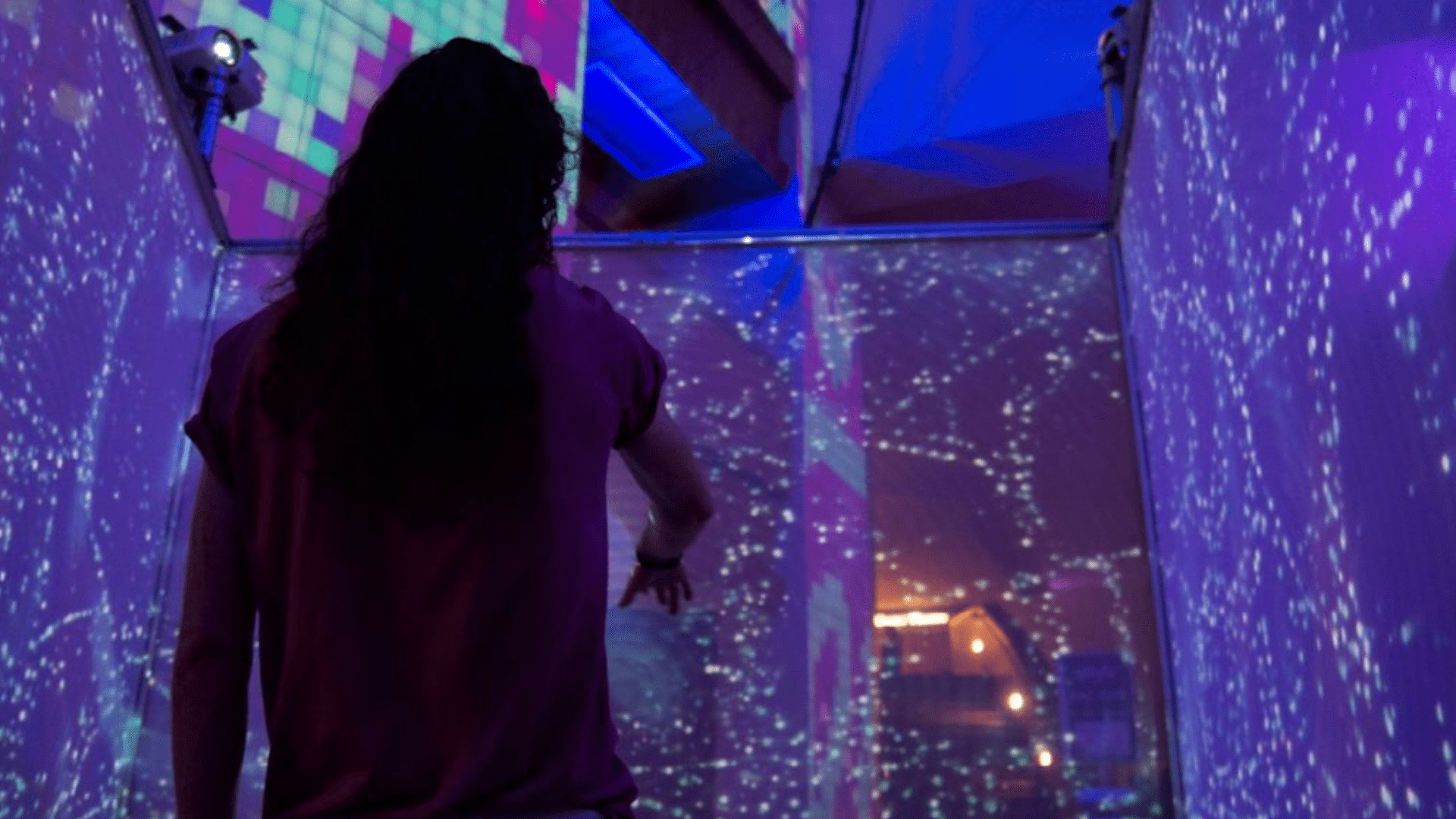 Person walks through immersive media outdoor display at night.