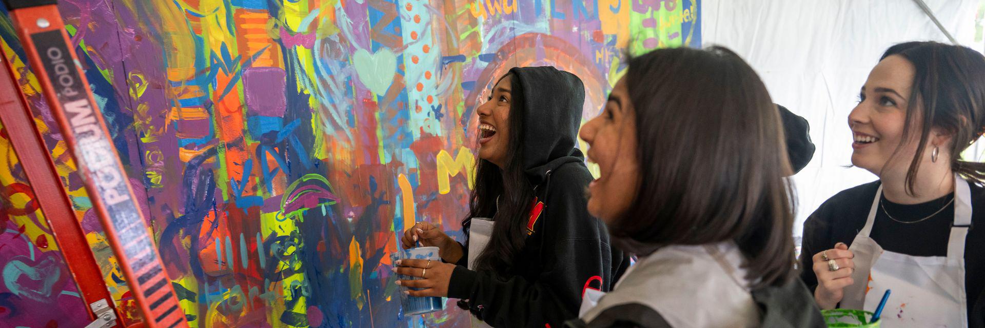 Students paint a colorful mural at Maryland Day.