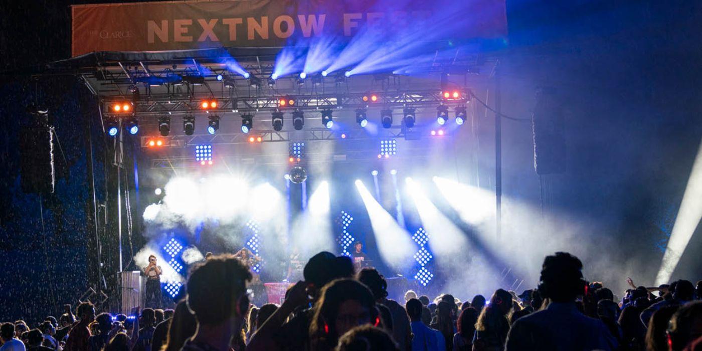 A crowd watches an outdoor concert.