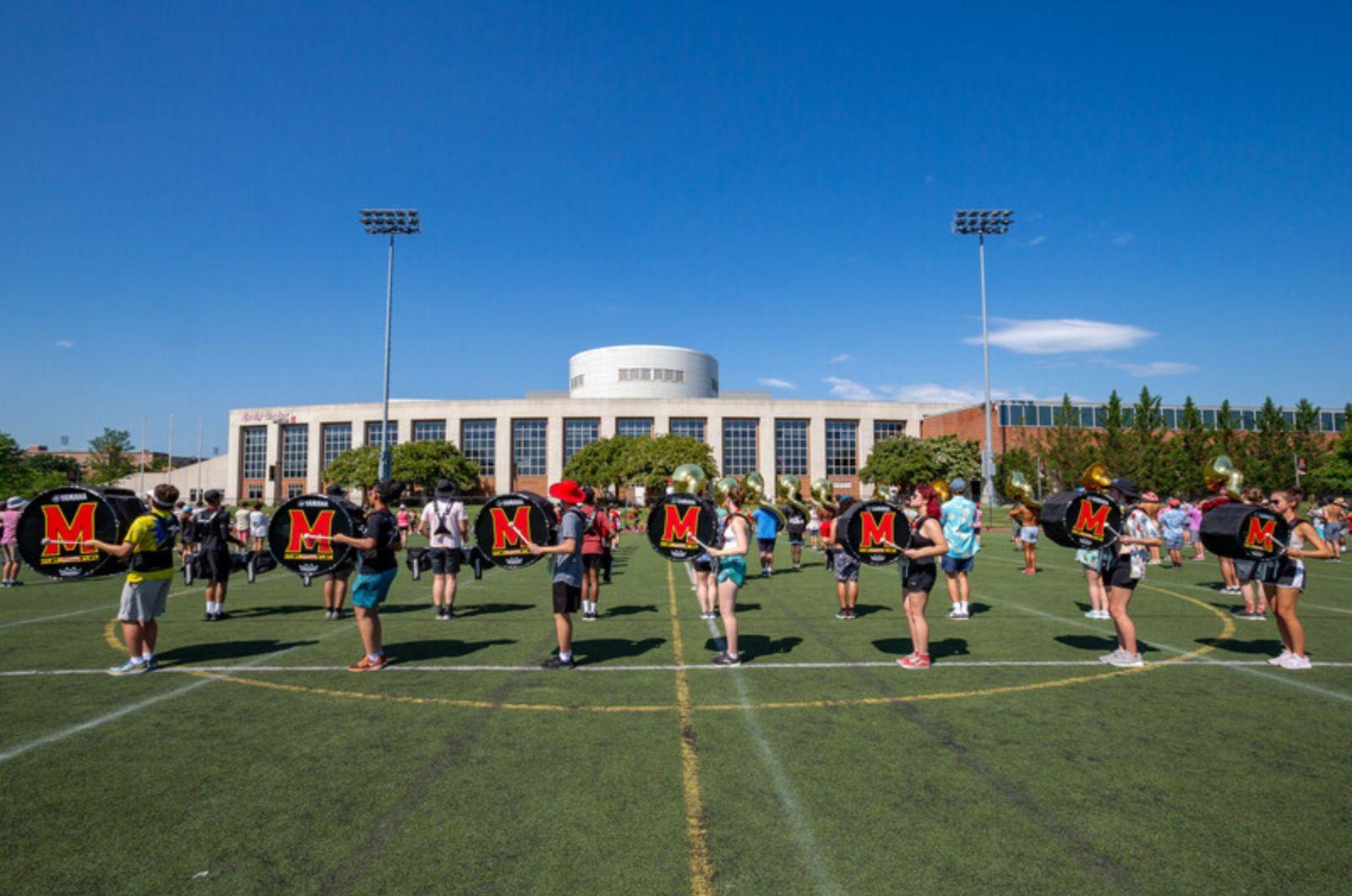 The Mighty Sound of Maryland Marching Band practices outside on a field.