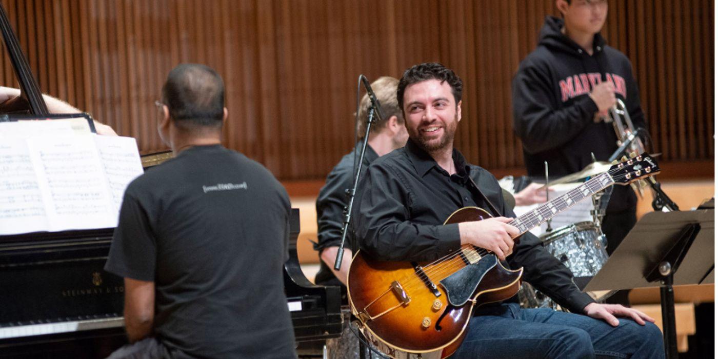 man playing guitar in a concert