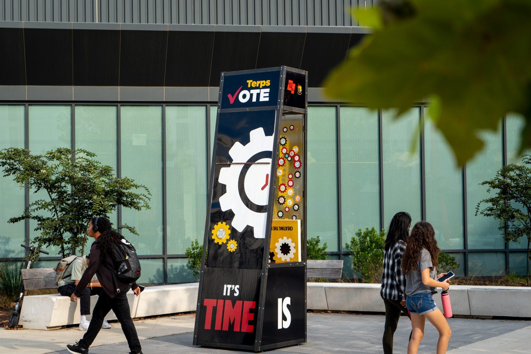 Students walk past the VOTE (Fearlessly!) pop-up.