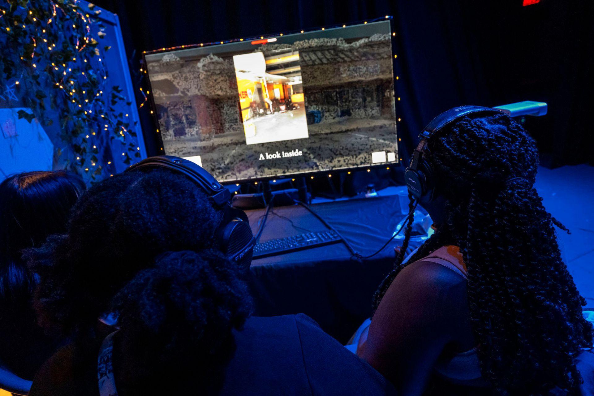 Students watch an immersive video on a computer.