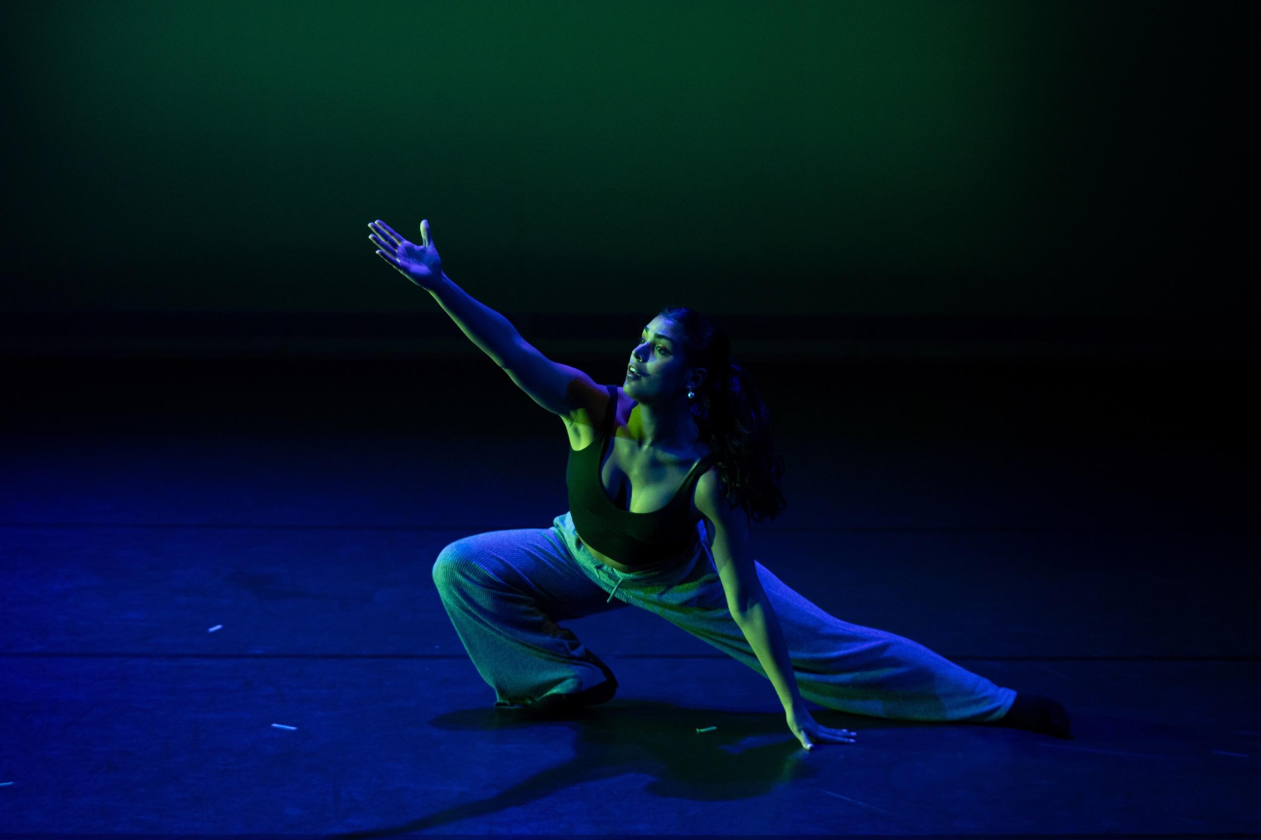 A dancer on a dark stage.