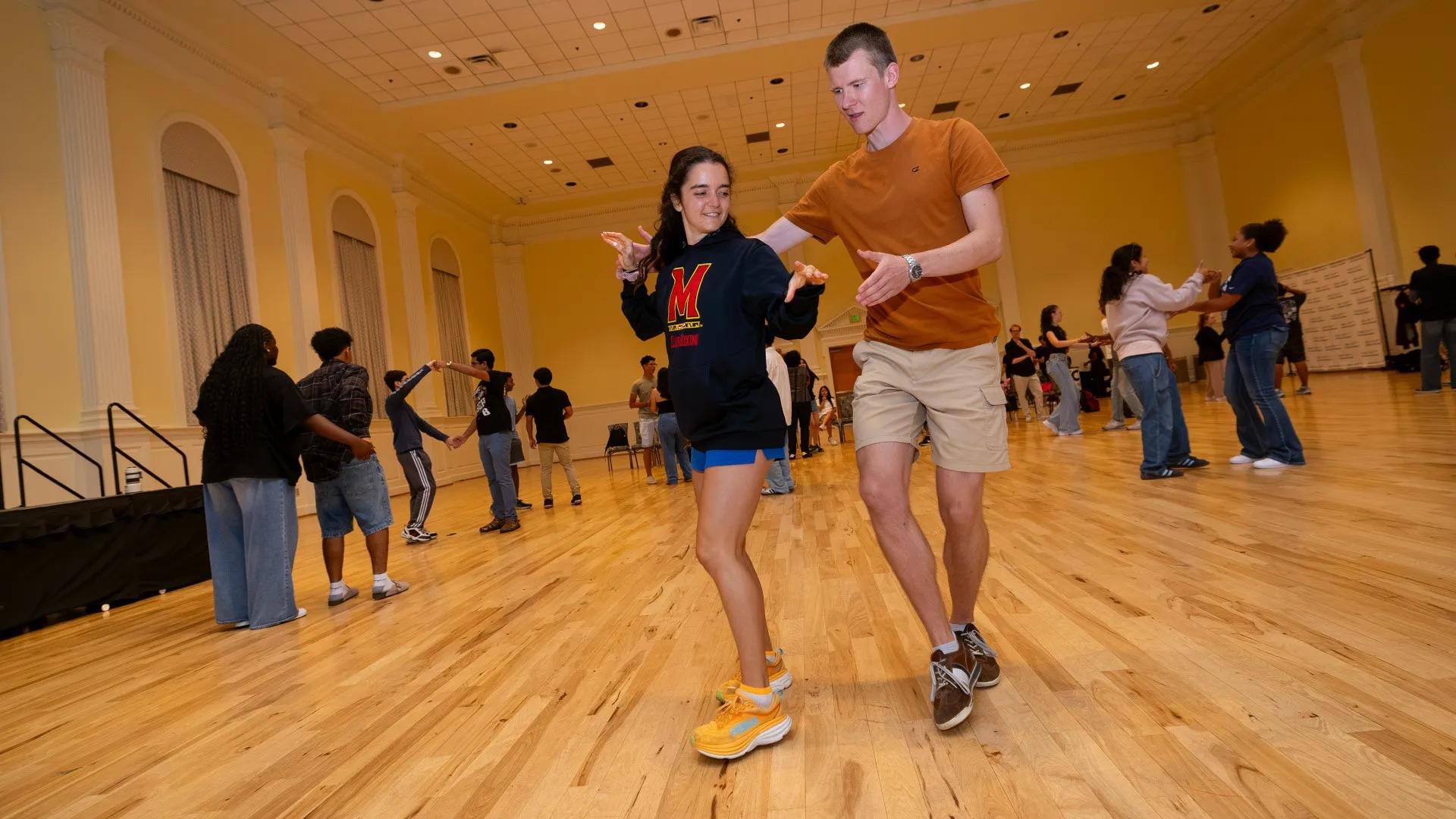 Students dancing together in a ballroom.
