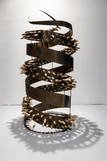 A huge sculpture of a steel spiral helix with wood bolts.